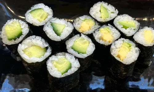 Cucumber and avocado sushi rolls on plate.