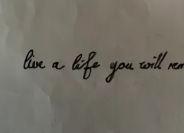 Handwritten quote on paper surface.