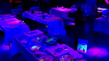 Maltische bei Schwarzlicht beleuchtet.