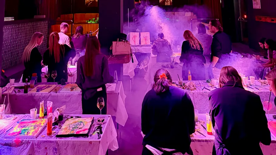 People painting in a dimly lit studio.