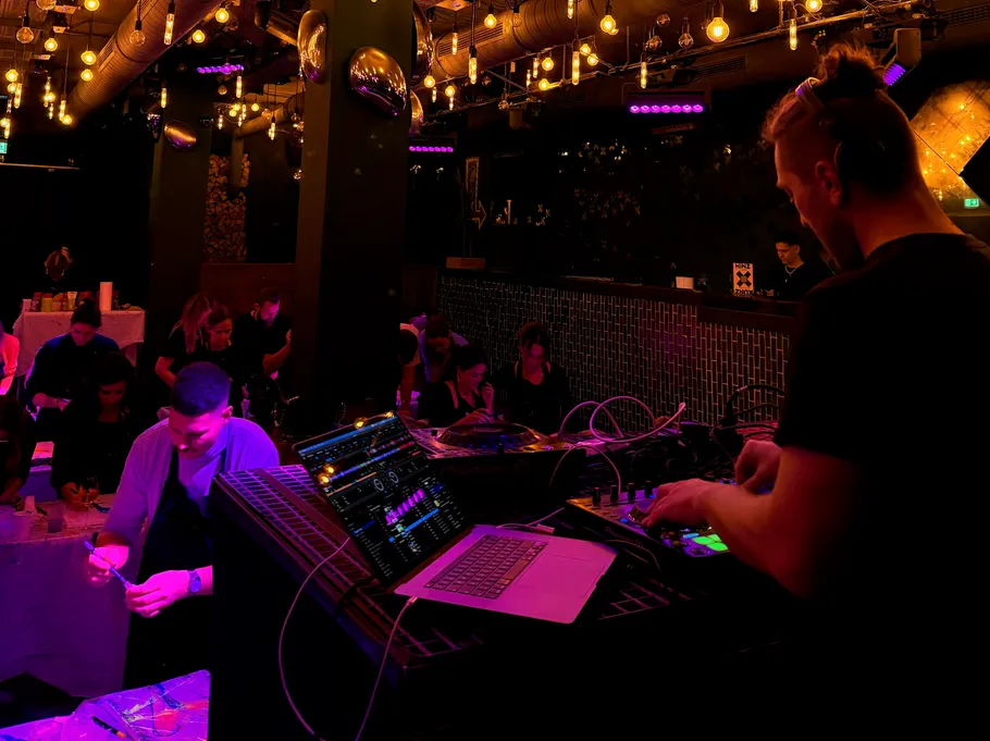 DJ spielt Musik in schummrigem Club.