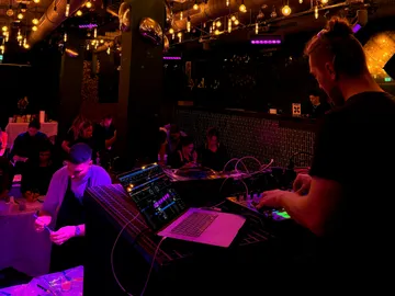DJ spielt in einem schwach beleuchteten Club.