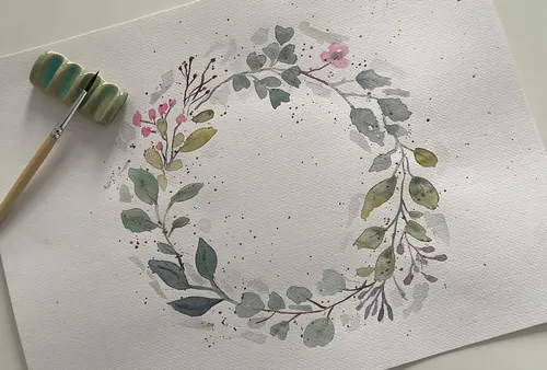 Watercolor leaf wreath on white paper.