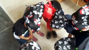 Children wearing pirate hats huddled together indoors.