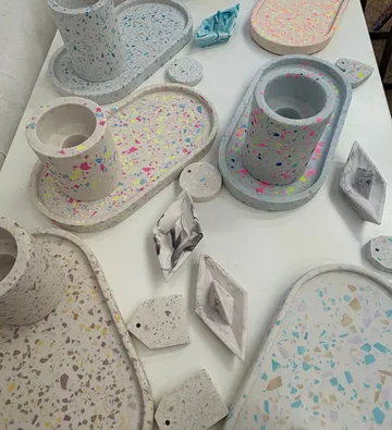 Bunte Terrazzo-Gegenstände auf weißem Tisch.