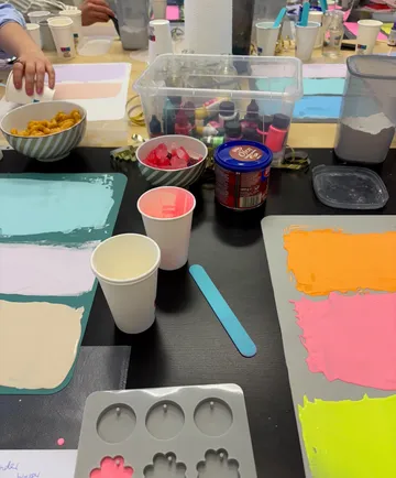 Crafting station with paints, molds, and snacks.
