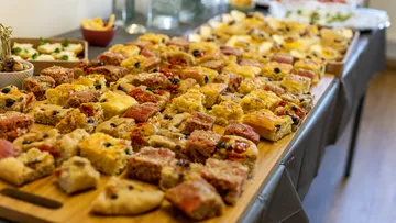 Assorted pizza slices on a wooden board.