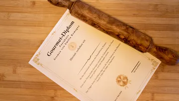 Nudelholz auf Gourmet-Diplom, Holzoberfläche.