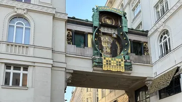 Ornate clock in architectural bridge between buildings.