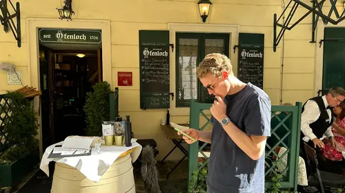 Mann liest Speisekarte vor einem Restaurant.