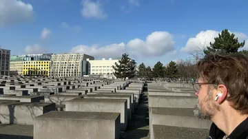 Mann betrachtet Holocaust-Memorial in städtischer Umgebung.