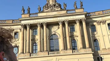 Historische Gebäudefassade mit Statuen und Säulen.