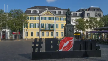 Statue and #Bonn sign in front of post office.
