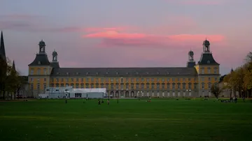 Historic building at dusk with lawn foreground.