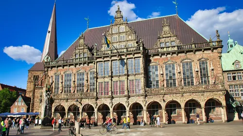 Historisches Gebäude mit Menschen und Fahrrädern draußen.