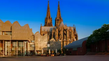 Kathedrale und modernes Gebäude unter klarem Himmel.