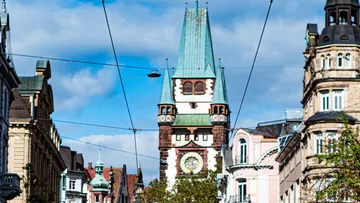 Historic clock tower amidst city buildings.