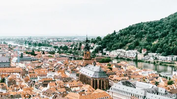 Cityscape with church, river, and hills.