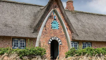 Reetdachhaus mit Walkieferknochenbogen.