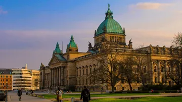 Historic building with green dome in urban setting.