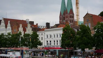 Historische Gebäude und Bäume mit Kirchtürmen.
