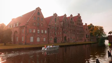 Boat passing historic buildings on canal.