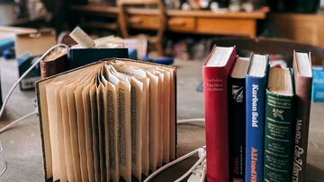 Bücher und Ladekabel auf einem Tisch.
