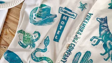 Shirt with Western-themed prints on wooden table.