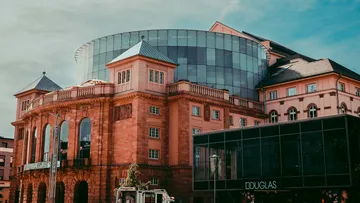 Historisches Theatergebäude mit modernem Glas-Anbau.