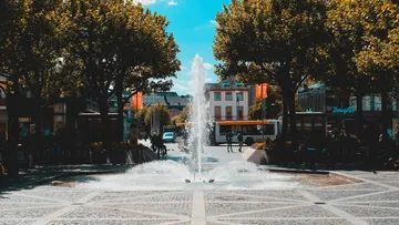 Brunnen sprüht Wasser auf Stadtplatz.