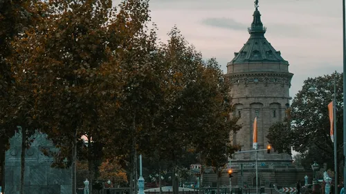 Historischer Wasserturm von Herbstbäumen umgeben.