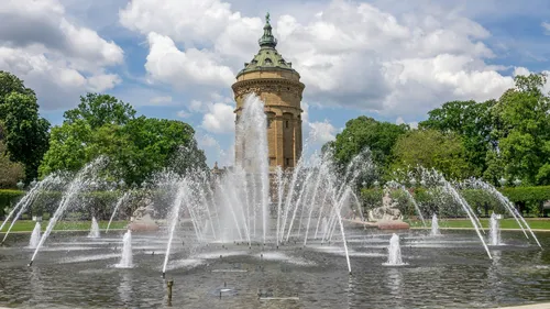 Springbrunnen sprüht Wasser vor Wasserturm.