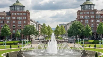 Fountain sprays water in a city square.
