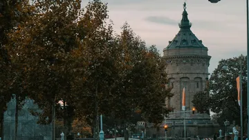 Historischer Turm von Bäumen umgeben bei Dämmerung.