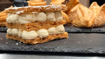 Geschichtetes Dessert mit Sahne auf Schieferplatte.
