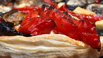 Nahaufnahme von Gemüsetarte mit roten Paprika.