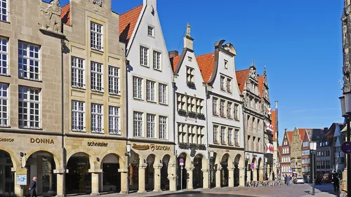 Historical buildings with arched walkways in city.