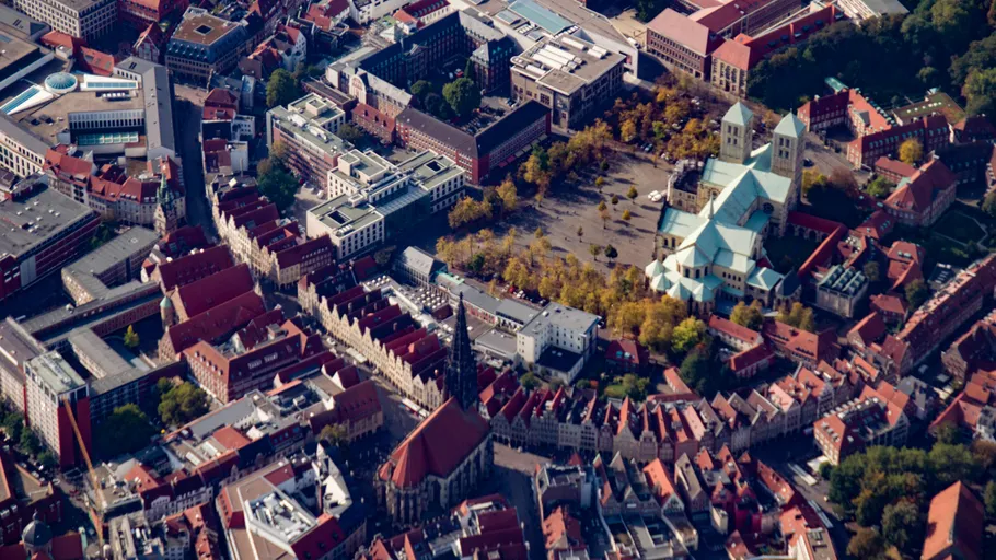Aerial view of a city with cathedral and buildings.