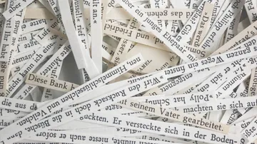 Cut paper strips with German text.