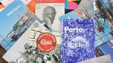 Assorted travel brochures and guides displayed.