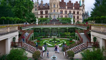 Grand castle with elaborate garden and stairs.