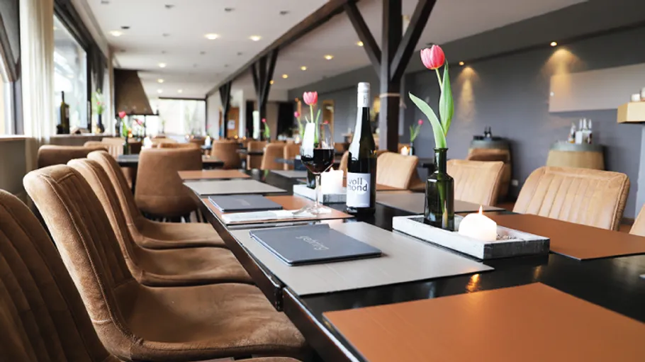 Elegantes Restaurant mit Tulpen und Weinflaschen.