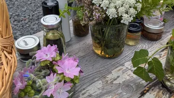 Blumen und Gläser auf rustikalem Holztisch.
