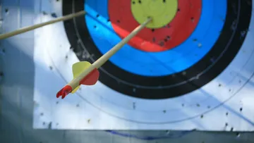 Arrows hitting a colorful archery target.