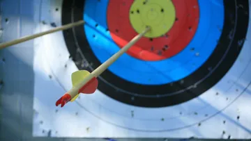 Arrow hitting bulls-eye on target face.