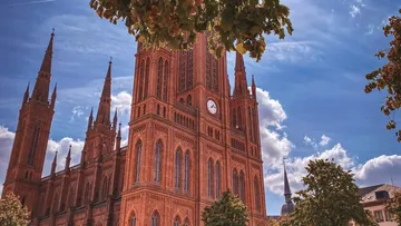 Gotische Kathedrale mit Uhr unter blauem Himmel.