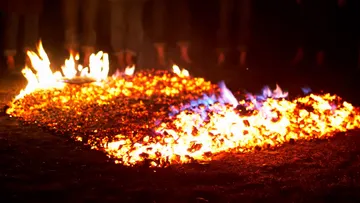 Glowing coals arranged for firewalking at night.