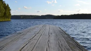 Wooden pier extending into calm lake.