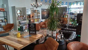 Gemütliche Whisky-Bar mit Ledersesseln und Dekor.