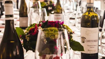 Weinflaschen und Gläser auf elegantem Tisch.